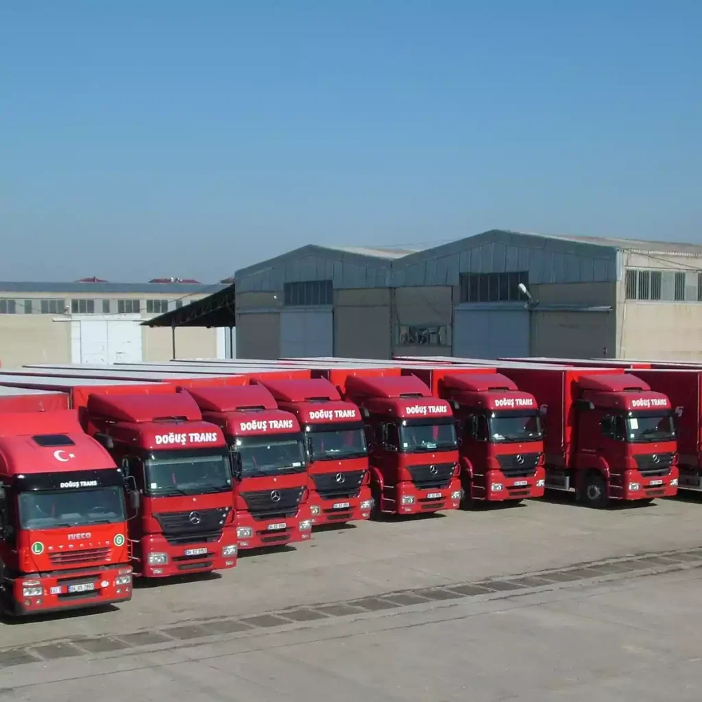 Multiple Doğuş International Transport trucks parked at a loading station.