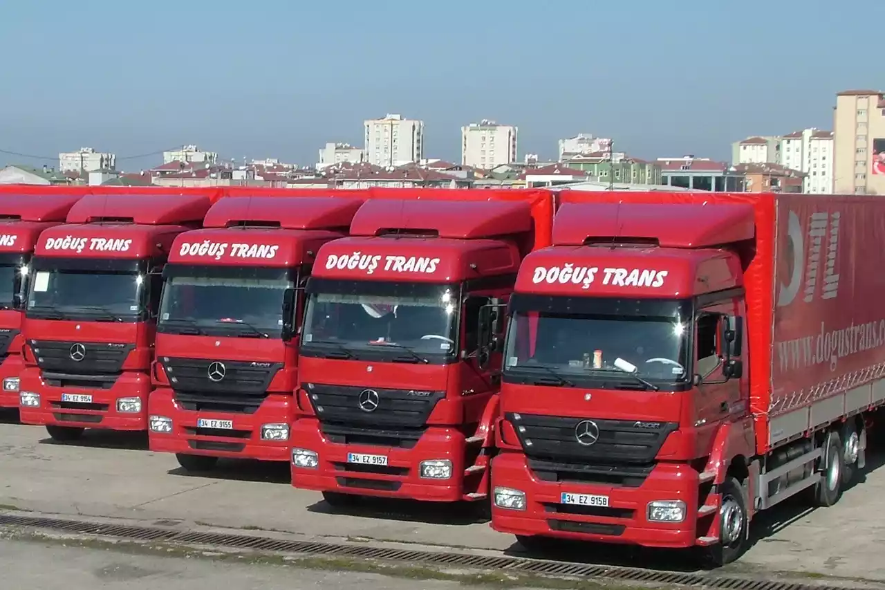 Multiple Doğuş International Transport trucks parked at a loading station.